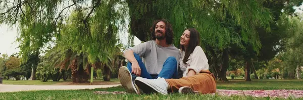 stock image Happy smiling couple talking while sitting on blanket in park