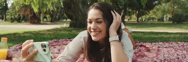 stock image Young woman relaxing in the park and making video call from mobile phone