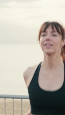 Formda bir çift, sokak antrenmanından önce senkronize bir şekilde atlayıp ısınıyor. Kamera dönüyor, kadına odaklan.