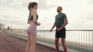 Dışarıda antrenman yapan aktif bir çift, çömelmiş erkek ve dişi sporcular.