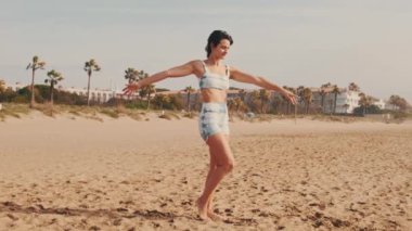 Sahilde yoga yapan genç bir kadının portresi, deniz kenarında yoga dersi, zarif bir bayan atlet.