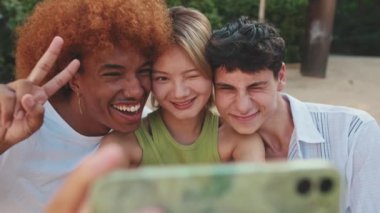 Arkadaşların cep telefonuyla medyayı paylaşırken, akıllı telefondan video izlerken ve tartışırken eğlendikleri yakın çekim.