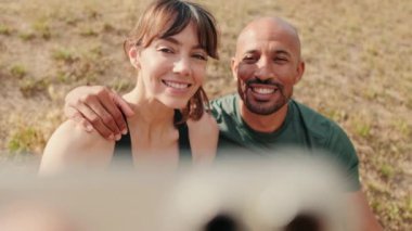 Birbirlerine aşık sportif çiftin yakın çekim görüntüsü. Rahatlama ve açık havada akıllı telefon kullanmaları. Selfie çekmeleri.