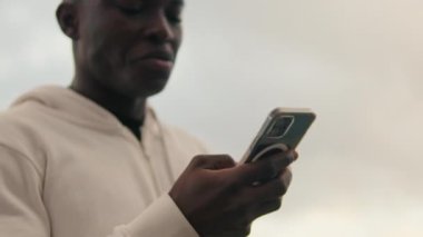 Akıllı telefon kullanan genç bir adamın yakın çekimi, telefona odaklan.