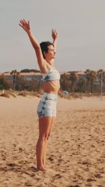 Sahilde yoga yapan kız, deniz kenarında yaz sporu yapan.