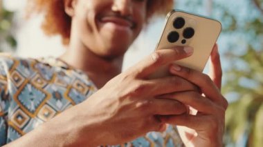 Akıllı telefondan yazı yazan bir adamın ellerine yakın çekim. Web, sosyal medya