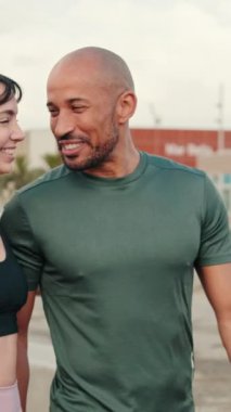 Deniz kenarında yürüyen ve kucaklaşan sportif bir çift, bir erkekle bir kadın arasındaki yakın diyalog.