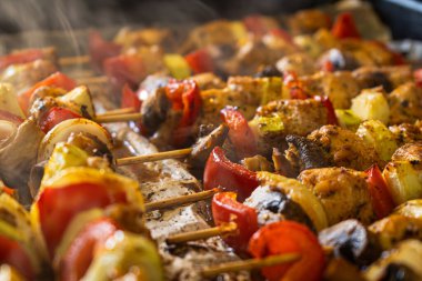 Mantar, soğan, kırmızı biber ve kabakla kaplanmış baharatla kaplı taze ve lezzetli ızgara tavuk şiş yakın plan fotoğrafı. Izgara ya da parti yemeği olarak ideal.. 