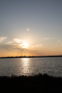 Denizin üzerinde gün batımının silueti.