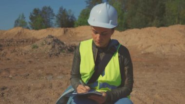 Kadın mühendis işlerle ilgili notlar alıyor