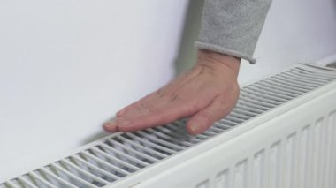 Tanımlanamayan bir yüze sahip kişi radyatör sıcaklık kontrolörlerini kontrol eder, seçer ve ısı düzenleyicilerinin kurulumunu yapar.