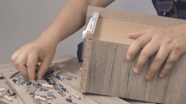 Marangozdan mobilya toplayıcısına tanınmaz halde olan kişi tornavidayla çalışır.