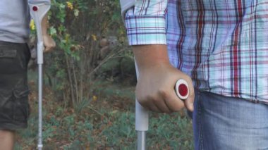 Koltuk değneklerinde tanınmayan iki engelli insan.