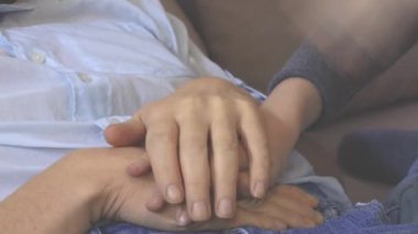 Tanımlanamayan yüzleri olan iki kişi elleriyle bir oyun oynuyor, sadece kolları görünüyor.