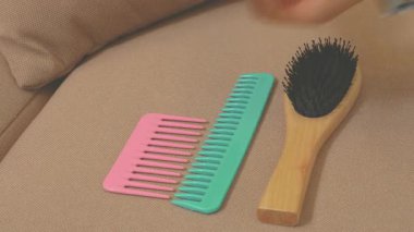 Tanınmayacak halde olan kişi, kirli tarağı saçla doldurup temiz olanını alıyor, sadece kolları görünüyor.