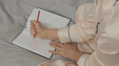 Yüzü tanınmayan kişi stresi büyük kırmızı harflerle yazar. Sadece bacakları ve kolları görünür.