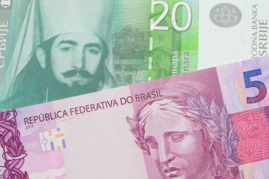 Brezilya 'dan gelen pembe ve mor beş gerçek banknotun makro görüntüsü, Sırbistan' dan gelen yeşil ve beyaz 20 dinar banknotla eşleştirildi. Makro çekimde yakın çekim.