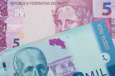 Brezilya 'dan gelen pembe ve mor beş banknotun makro görüntüsü Kosta Rika' dan gelen renkli iki bin colonluk banknotla eşleştirildi. Makro çekimde yakın çekim.