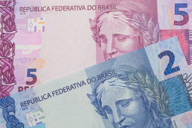 Brezilya 'dan gelen pembe ve mor beş banknotun makro görüntüsü ile Brezilya' dan gelen iki gerçek banknot eşleştirildi. Makro çekimde yakın çekim.