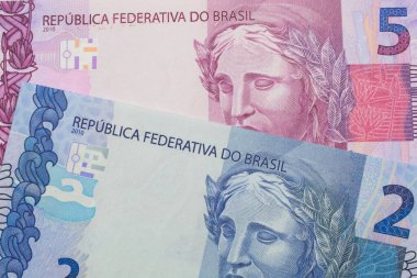 Brezilya 'dan gelen pembe ve mor beş banknotun makro görüntüsü ile Brezilya' dan gelen iki gerçek banknot eşleştirildi. Makro çekimde yakın çekim.
