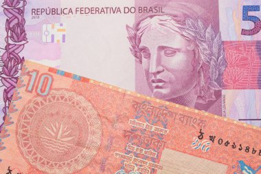 Brezilya 'dan gelen pembe ve mor beş banknotun makro görüntüsü Bangladeş' ten gelen kırmızı on taka banknotuyla eşleştirildi. Makro çekimde yakın çekim.