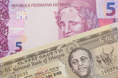 Brezilya 'dan gelen pembe ve mor beş banknotun makro görüntüsü gri bir Etiyopya doğum faturasıyla eşleştirildi. Makro çekimde yakın çekim.