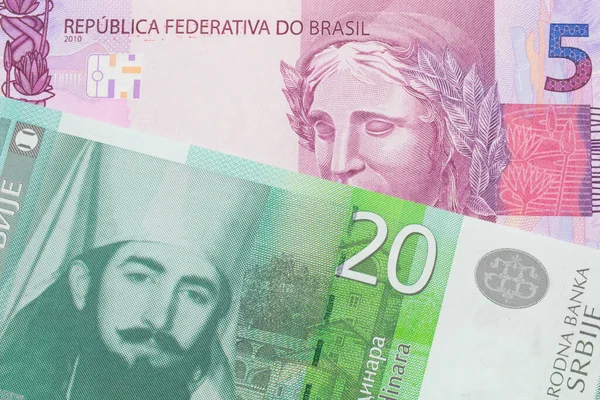 ブラジルのピンクと紫の5つの本物の銀行券のマクロ画像は セルビアの緑と白の20ディナール紙幣と対になりました マクロでショットを閉じる — ストック写真