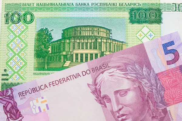 ブラジルのピンクと紫の5つの本物の銀行券のマクロ画像は ベラルーシの緑の100ルーブル紙幣と対になりました マクロでショットを閉じる — ストック写真