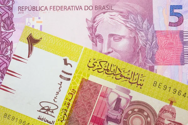 ブラジルからのピンクと紫の5つの本物の銀行券のマクロ画像は スーダンからの緑の2ポンドの銀行券と対になりました マクロでショットを閉じる — ストック写真