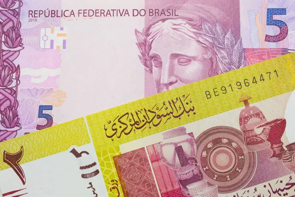ブラジルからのピンクと紫の5つの本物の銀行券のマクロ画像は スーダンからの緑の2ポンドの銀行券と対になりました マクロでショットを閉じる — ストック写真