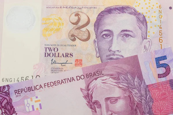 ブラジルのピンクと紫の5つの本物の銀行券のマクロ画像は シンガポールからの紫と白 プラスチックの2ドル札と対になりました マクロでショットを閉じる — ストック写真