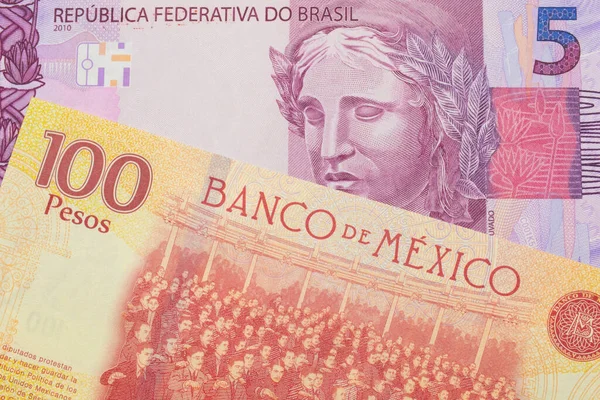 ブラジルからのピンクと紫の5つの本物の銀行券のマクロ画像は メキシコからの赤と黄色の100ペソ札と対になりました マクロでショットを閉じる — ストック写真