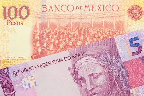 一张巴西面额为粉色和紫色的5张真实钞票的宏观图片 与墨西哥面额为100比索的红黄钞票搭配在一起 在宏观上拍的特写 — 图库照片