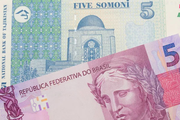 来自巴西的一张粉色和紫色五张真实钞票的宏观图片 与来自塔吉克斯坦的一张蓝色和白色五张索莫尼钞票搭配在一起 在宏观上拍的特写 — 图库照片