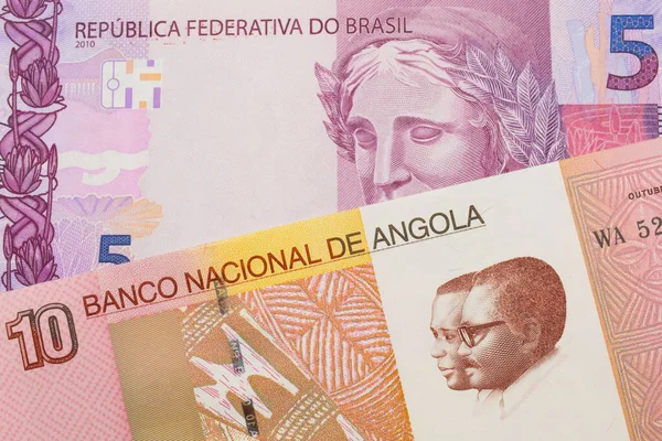 stock image A macro image of a pink and purple five real bank note from Brazil paired up with a colorful ten kwanza bank note from Angola.  Shot close up in macro.