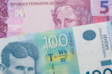 Brezilya 'dan gelen pembe ve mor beş gerçek banknotun makro görüntüsü yüz Sırp dinar banknotuyla eşleştirildi. Makro çekimde yakın çekim.