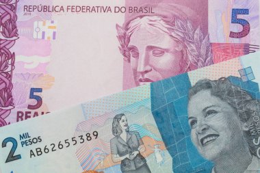 Brezilya 'dan gelen pembe ve mor beş banknotun makro görüntüsü Kolombiya' dan gelen mavi iki bin banknotla eşleştirildi. Makro çekimde yakın çekim.