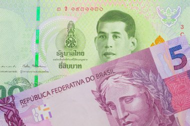 Brezilya 'dan gelen pembe ve mor beş banknotun makro görüntüsü Tayland' dan gelen 20 baht 'lık yeşil banknotla eşleştirildi. Makro çekimde yakın çekim.