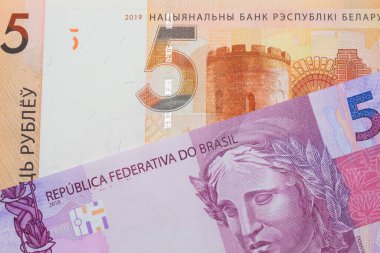 Brezilya 'dan gelen pembe ve mor beş banknotun makro görüntüsü, Belarus' tan gelen beş ruble turuncu banknotla eşleştirildi. Makro çekimde yakın çekim.