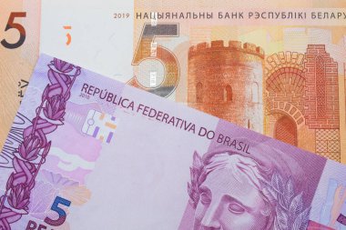 Brezilya 'dan gelen pembe ve mor beş banknotun makro görüntüsü, Belarus' tan gelen beş ruble turuncu banknotla eşleştirildi. Makro çekimde yakın çekim.