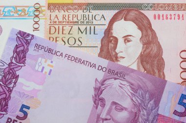 Brezilya 'dan gelen pembe ve mor beş banknotun makro görüntüsü Kolombiya' dan gelen kahverengi on bin banknotla eşleştirildi. Makro çekimde yakın çekim.