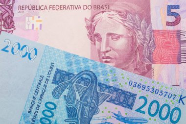 Brezilya 'dan gelen pembe ve mor beş banknotun makro görüntüsü mavi, iki bin Batı Afrika frangı banknotuyla eşleştirildi. Makro çekimde yakın çekim.