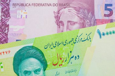 Brezilya 'dan gelen pembe ve mor beş banknotun makro görüntüsü İran' dan gelen mavi ve yeşil on bin riyal banknotla eşleştirildi. Makro çekimde yakın çekim.