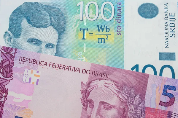 一张巴西面额为粉色和紫色的5张真实钞票的宏观图片 与一张一百塞尔维亚第纳尔的蓝白钞票搭配在一起 在宏观上拍的特写 — 图库照片