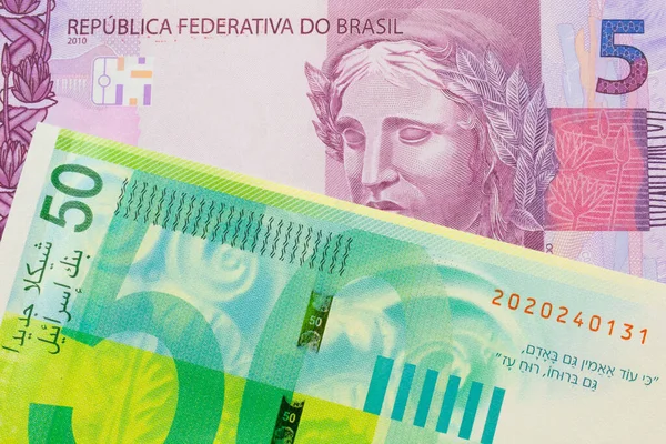ブラジルのピンクと紫の5つの本物の銀行券のマクロ画像は イスラエルの緑と白の50シェケルの銀行券と対になりました マクロでショットを閉じる — ストック写真