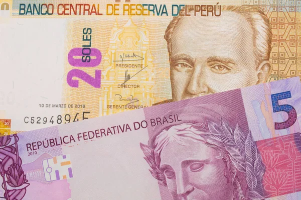 一张巴西面额为粉色和紫色五张真实钞票的宏观图片 与秘鲁面额为20索尔的米色钞票搭配在一起 在宏观上拍的特写 — 图库照片
