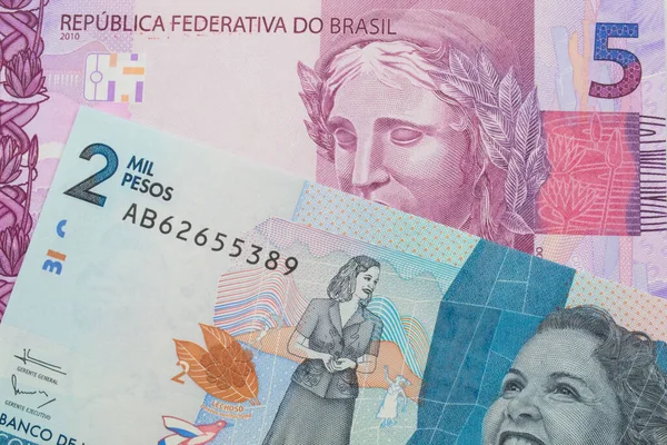ブラジルのピンクと紫の5つの本物の銀行券のマクロ画像は コロンビアの青い2000銀行券と対になりました マクロでショットを閉じる — ストック写真