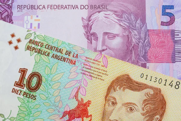 ブラジルのピンクと紫の5つの本物の銀行券のマクロ画像は アルゼンチンのカラフルな10ペソ紙幣と対になりました マクロでショットを閉じる — ストック写真
