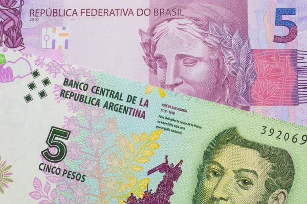 ブラジルのピンクと紫の5本の本物の銀行券のマクロ画像は アルゼンチンのカラフルな5ペソ紙幣と対になりました マクロでショットを閉じる — ストック写真
