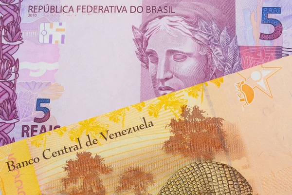 ブラジルのピンクと紫の5つの本物の銀行券のマクロ画像は ベネズエラのカラフルな黄色の5つのボリバル銀行券と対になりました マクロでショットを閉じる — ストック写真